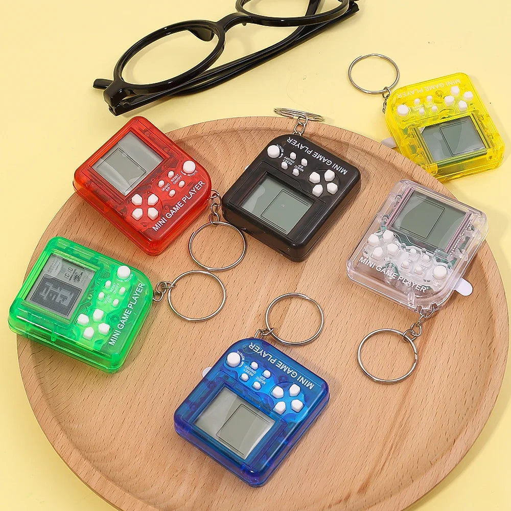 Set of colorful mini game players with keychains on a wooden board.