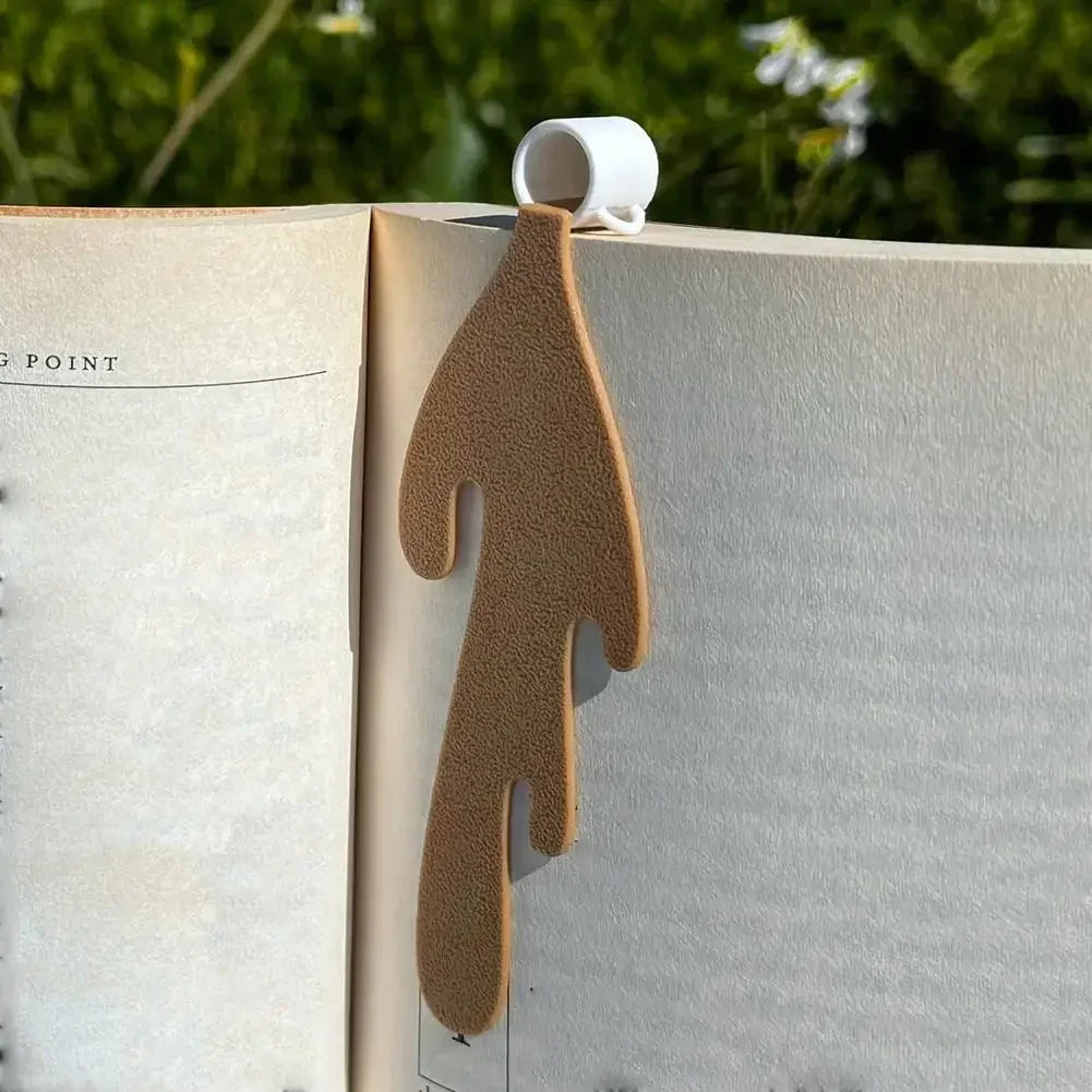 Spilled coffee bookmark with on a book page with outdoor background.