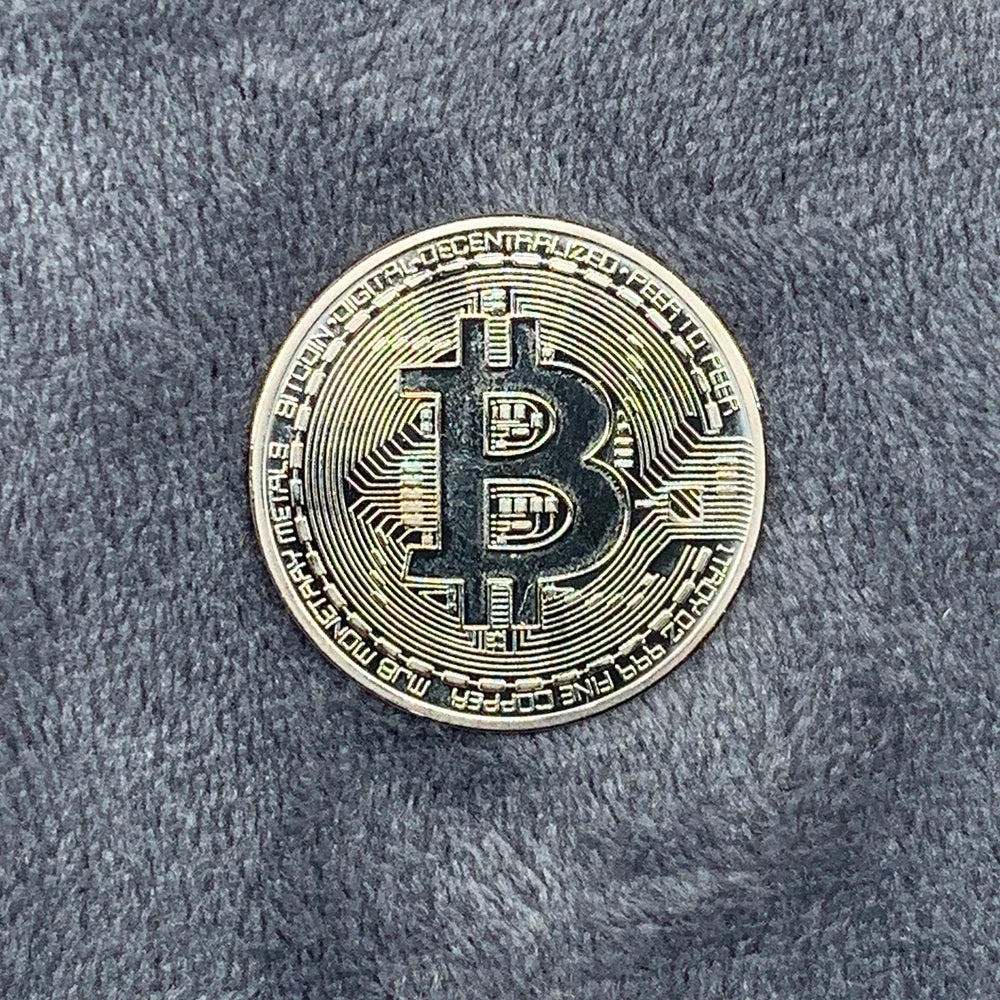 Bitcoin coin on a textured gray surface