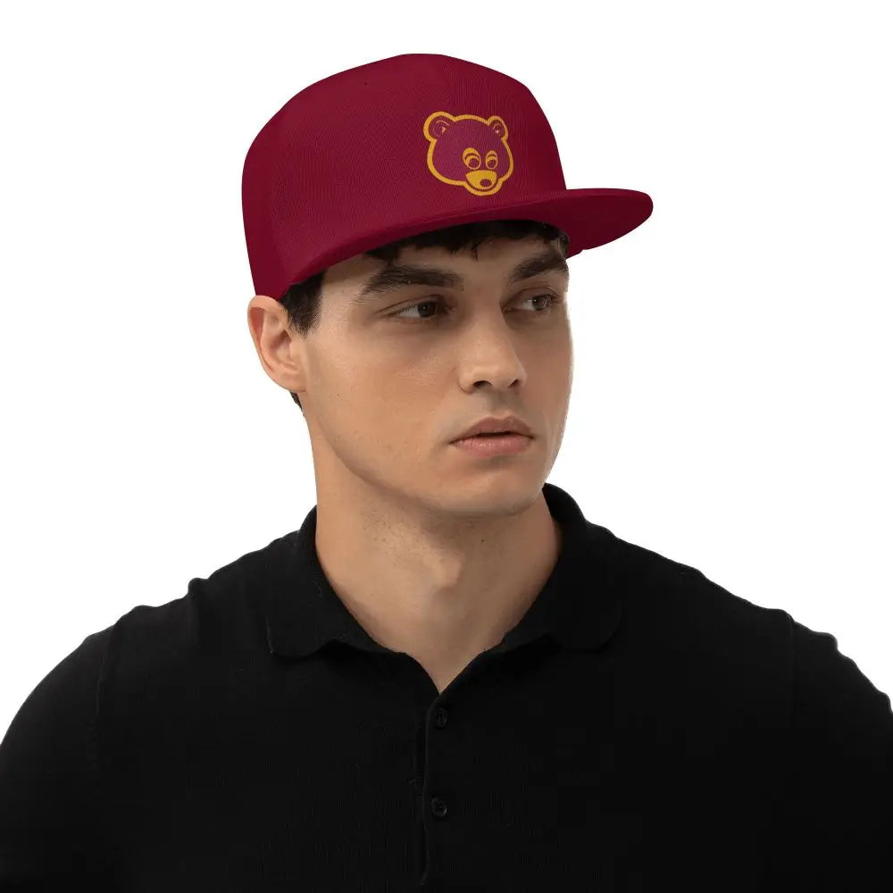 Model wearing Maroon 'College Dropout Kanye Snapback: Bear Mascot OSFA 9-Colorways' cap with yellow bear logo at an angle on a white background.