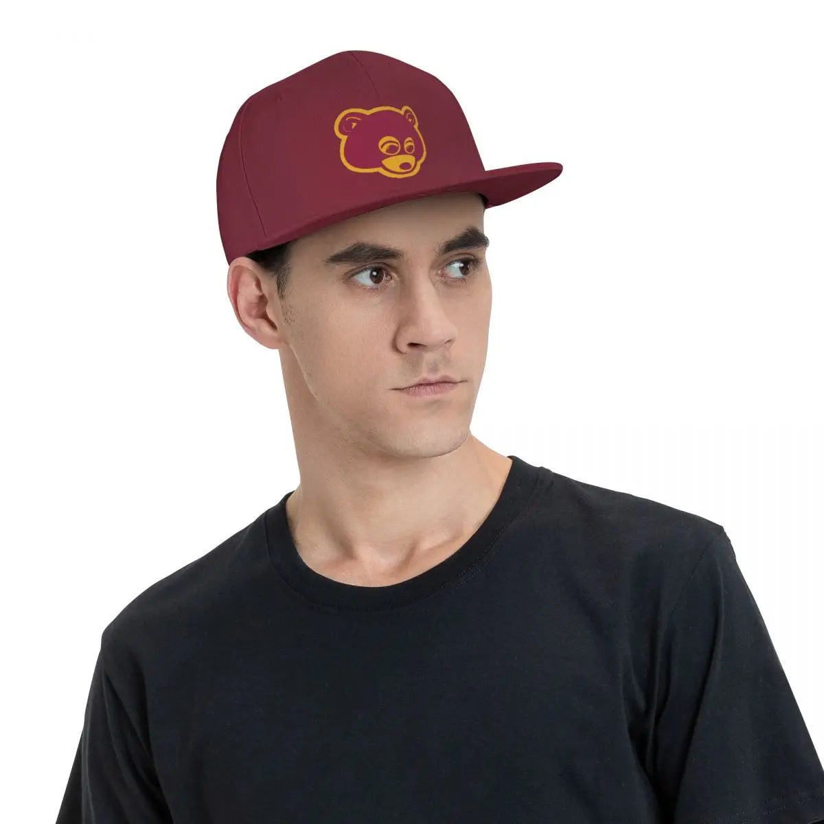 Maroon 'College Dropout Kanye Snapback: Bear Mascot OSFA 9-Colorways' cap with yellow bear logo on a white background with angled hat view on model.