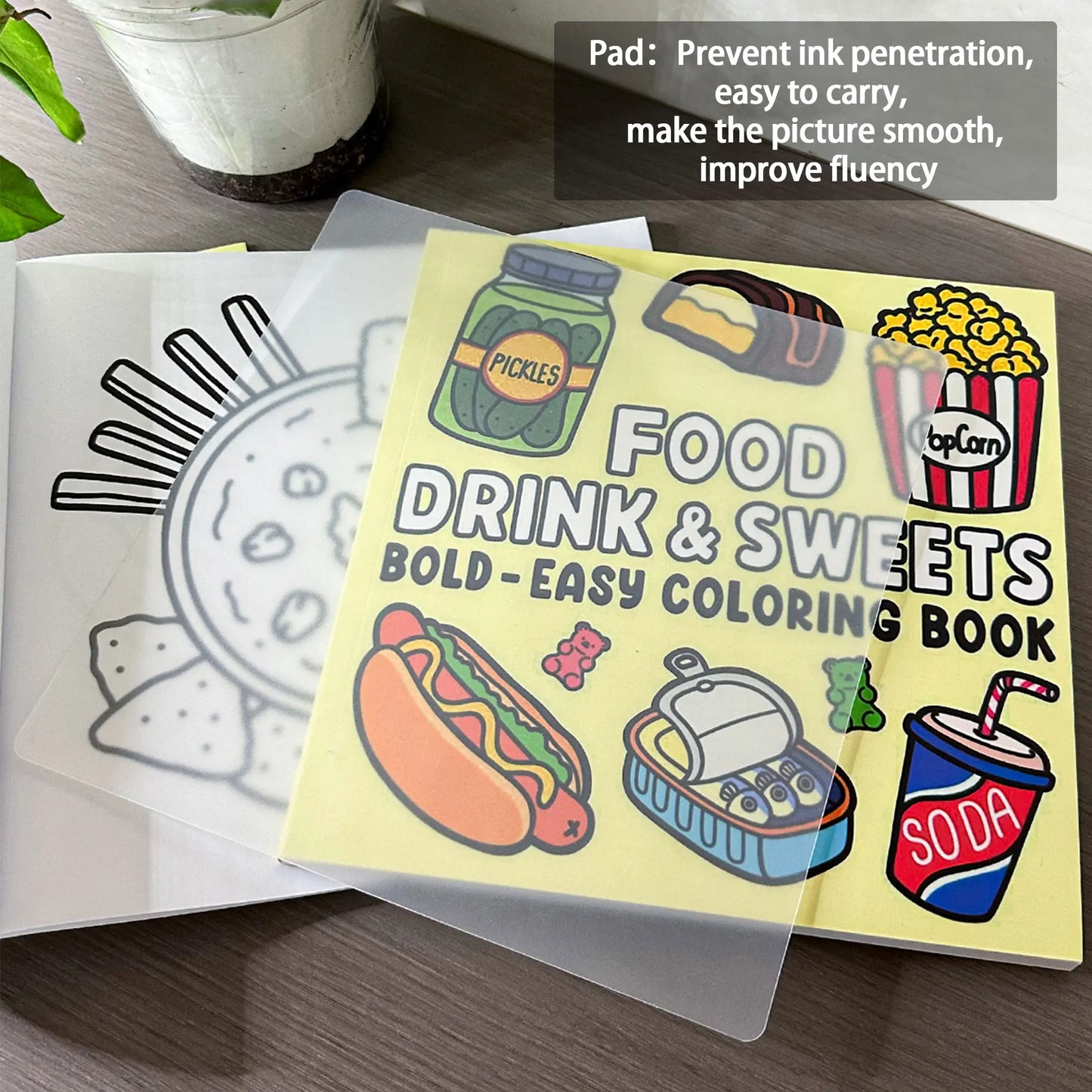 Coloring book with food-themed illustrations on a wooden surface