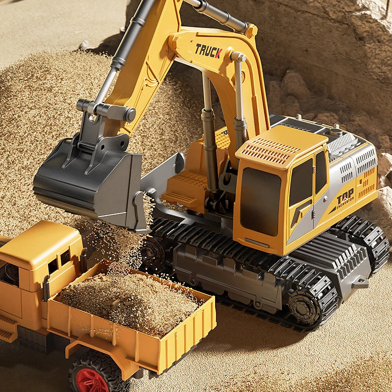 Toy excavator and truck on a sandy surface loading a dump truck.