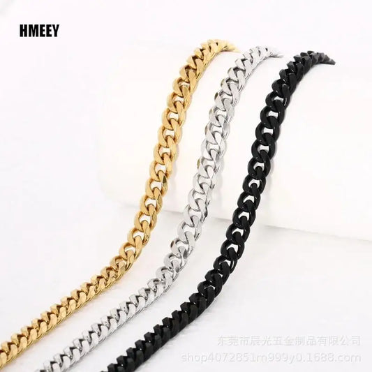 Three cuban link chain necklaces in gold, silver, and black on a white background.