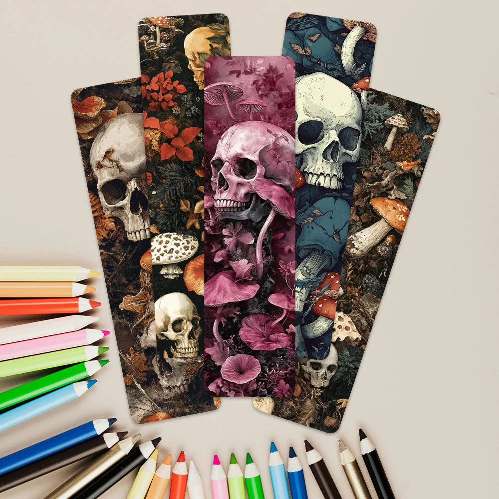 Colorful bookmarks with skull and nature designs, surrounded by markers on a light gray background