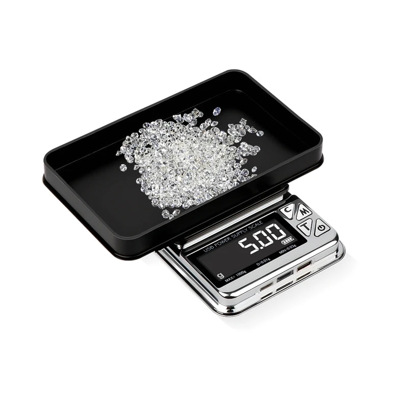 0.00 Digital scale with a black tray holding small diamonds on a white background