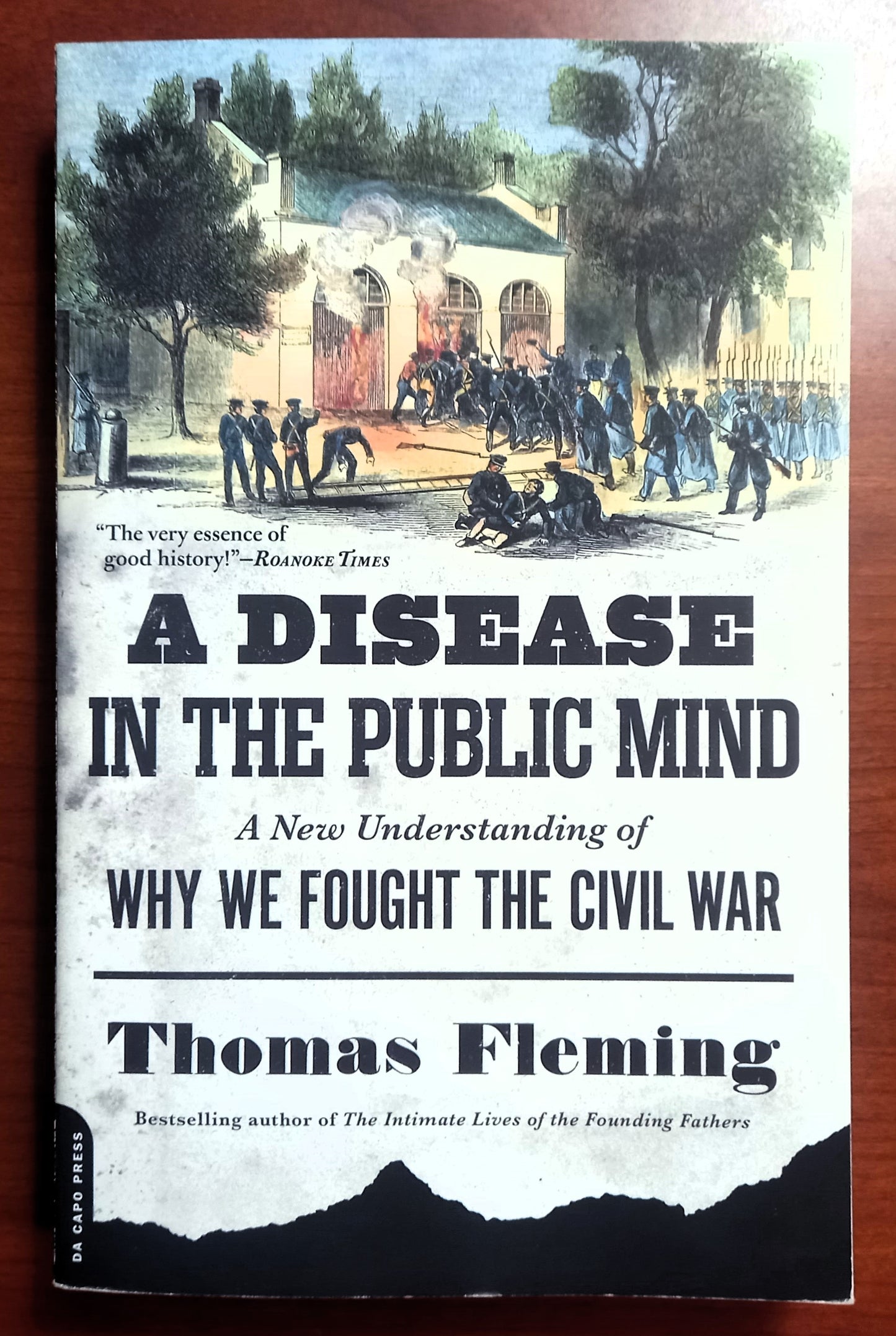 Book front cover of 'A Disease in the Public Mind: A New Understanding of Why We Fought the Civil War' by Thomas Fleming, on a woodgrain background.