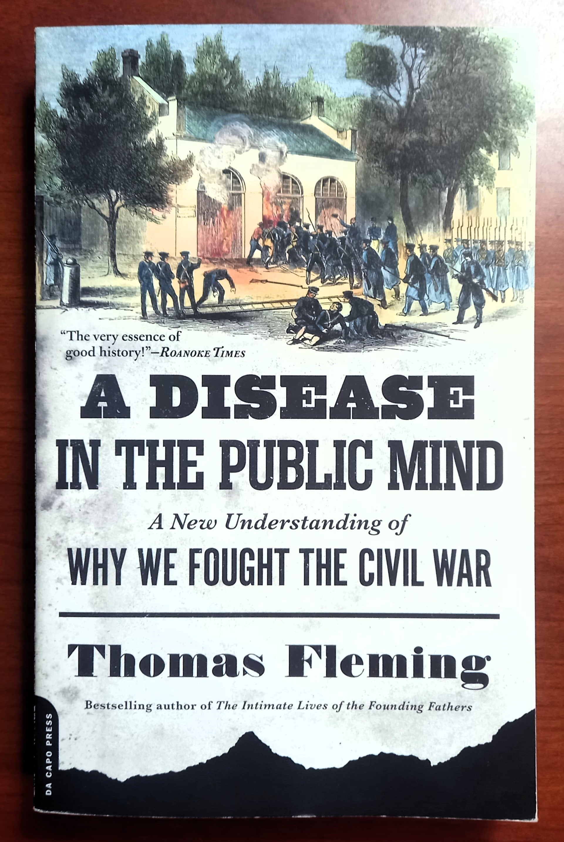 Book front cover of 'A Disease in the Public Mind: A New Understanding of Why We Fought the Civil War' by Thomas Fleming, on a woodgrain background.