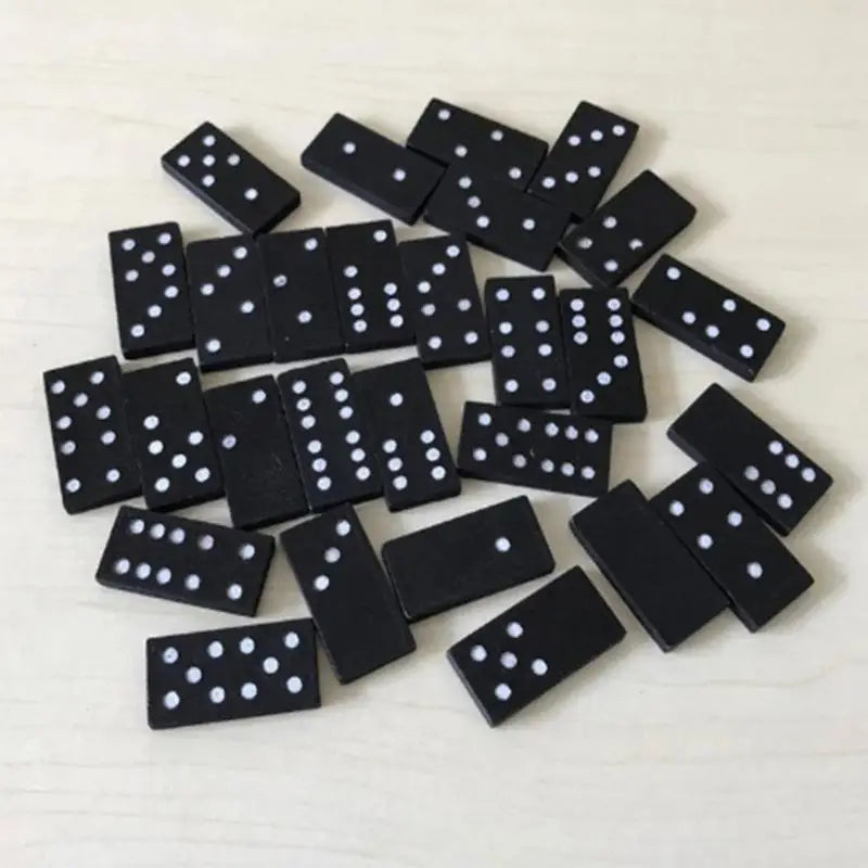 Set of black dominoes with white dots on a light background