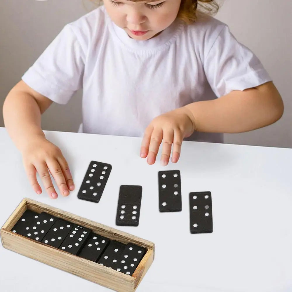 Child playing with dominoes on a white surface