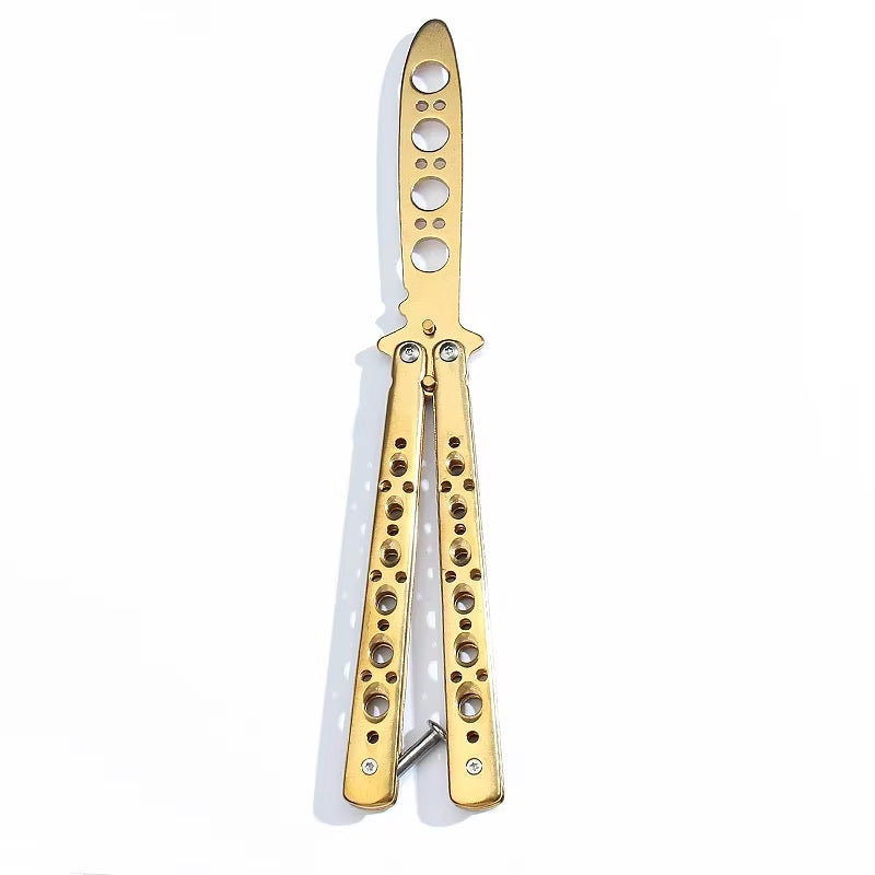 A gold-colored butterfly knife trainer with a dull blade and multiple holes in the handle for grip or decoration.