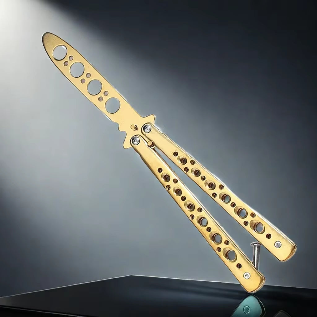 A gold-colored butterfly knife trainer with a dull blade and multiple holes in the handle for grip or handling.