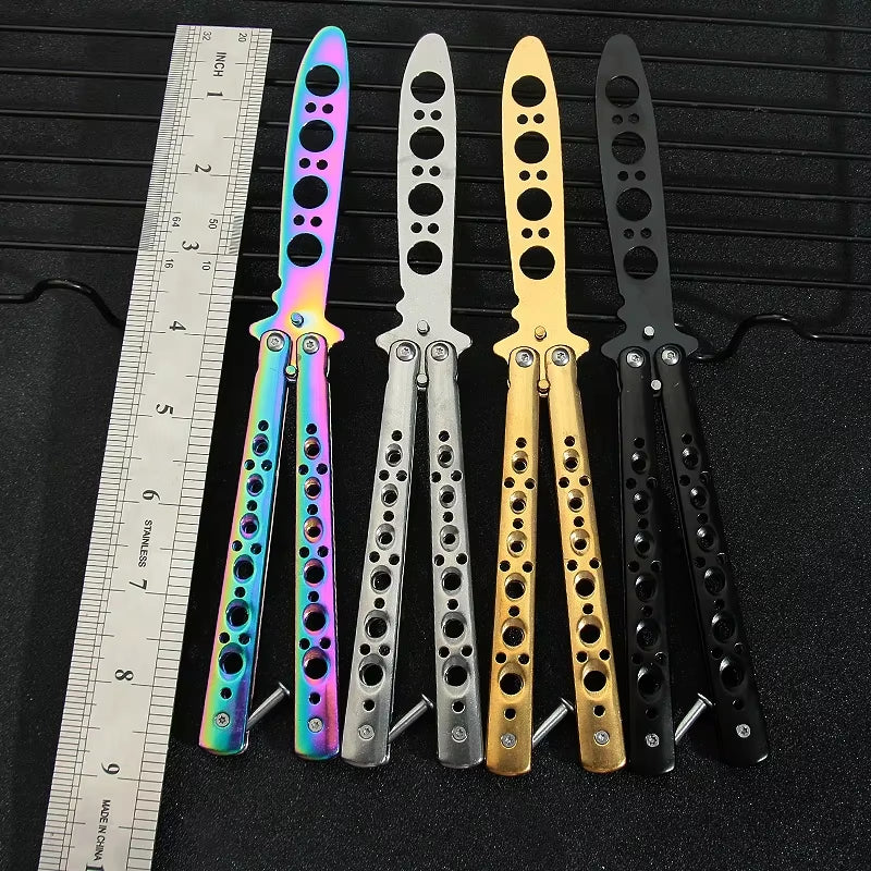 Four dull butterfly knife trainer options with a dull blades and multiple holes in the handle for grip or handling, featured next to a ruler for sizing.
