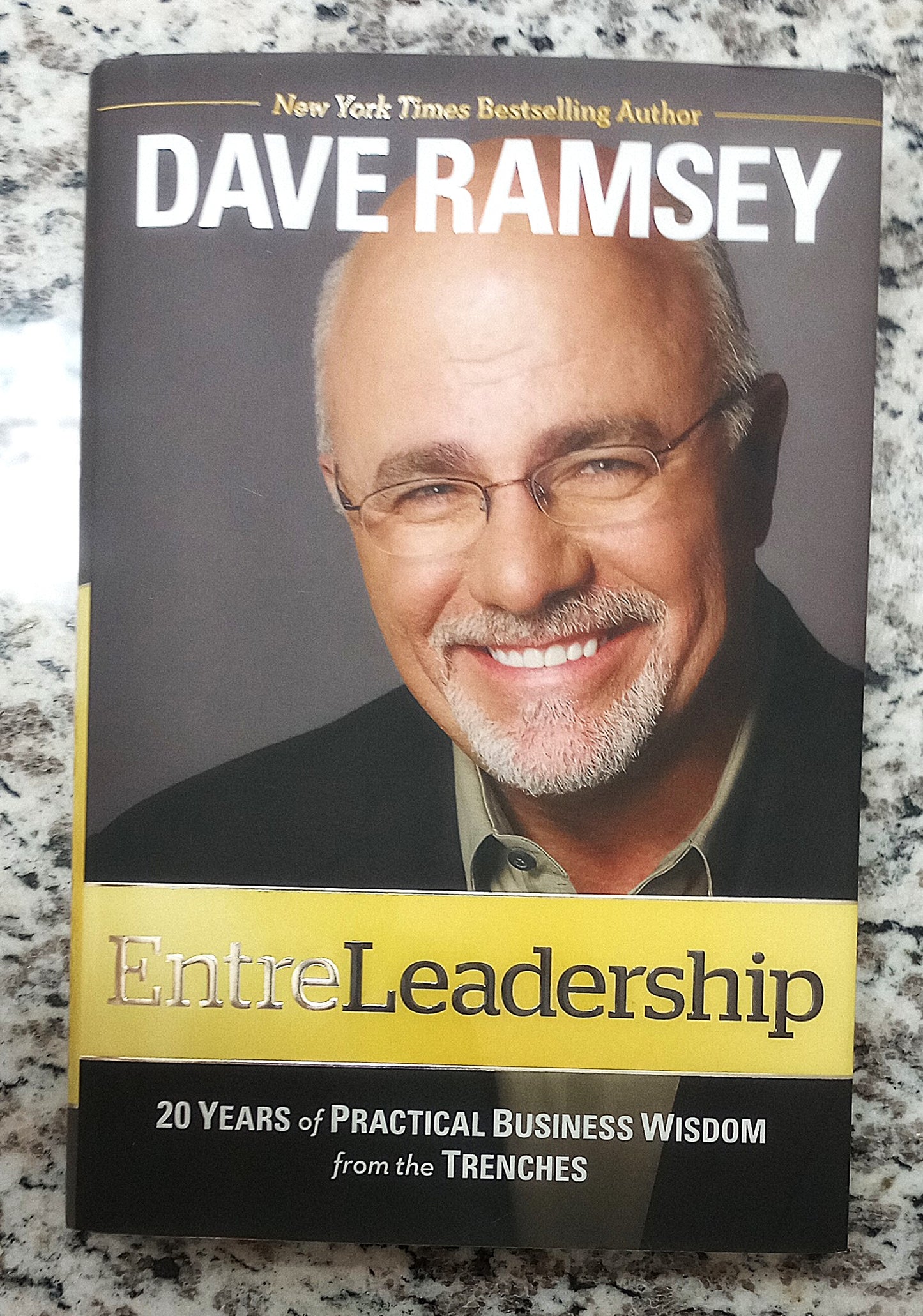 Book cover of 'EntreLeadership' by Dave Ramsey on a marble surface