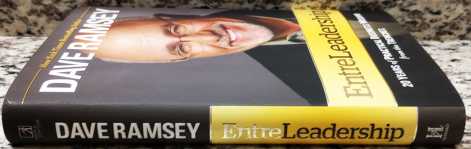 Book titled 'EntreLeadership' by Dave Ramsey on a wooden surface