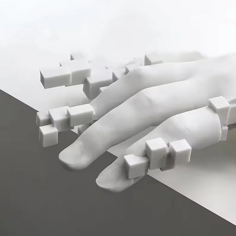 White abstract sculpture of a hand and geometric shapes on a gray surface