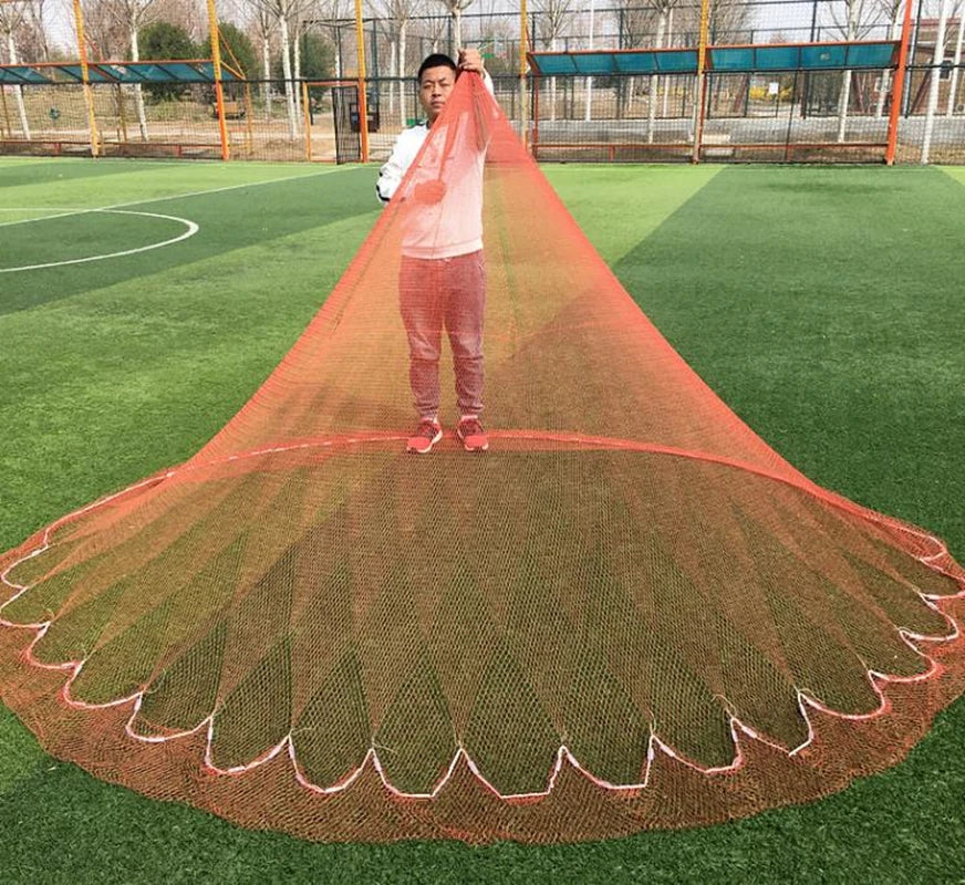 Person holding a large orange fishing net on a sports field
