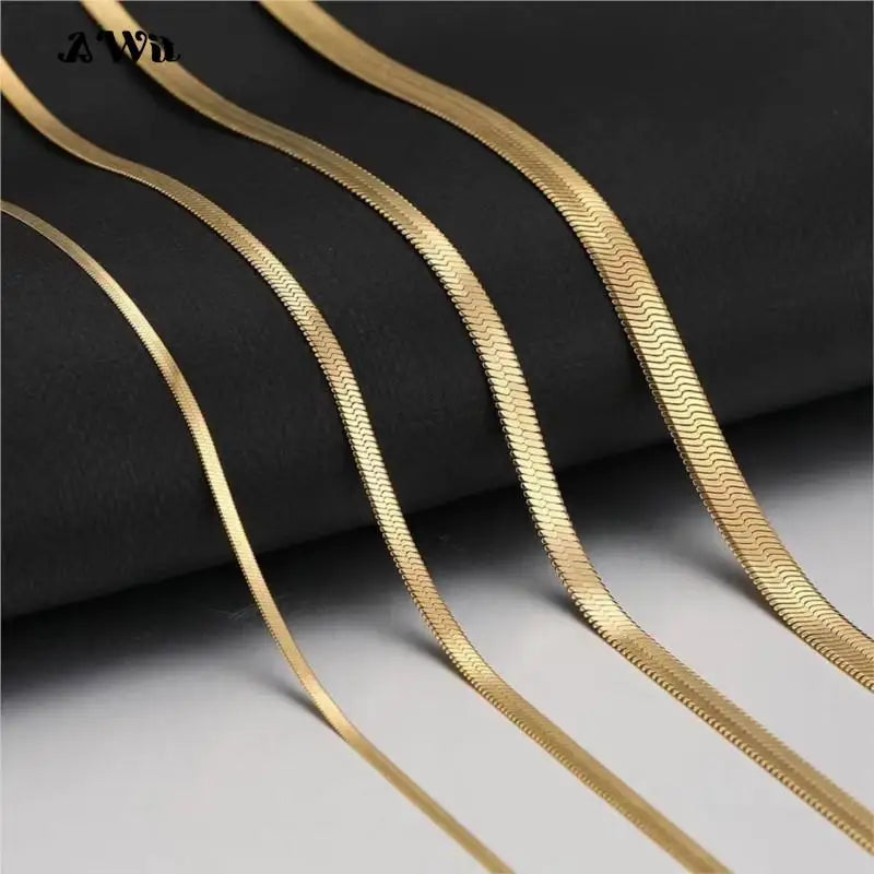 Gold flat chains in a variety of sizes laid in a row on display.