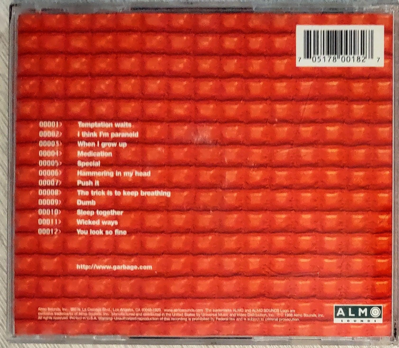 Back cover of a band Garbage music album with a red textured design and tracklist.