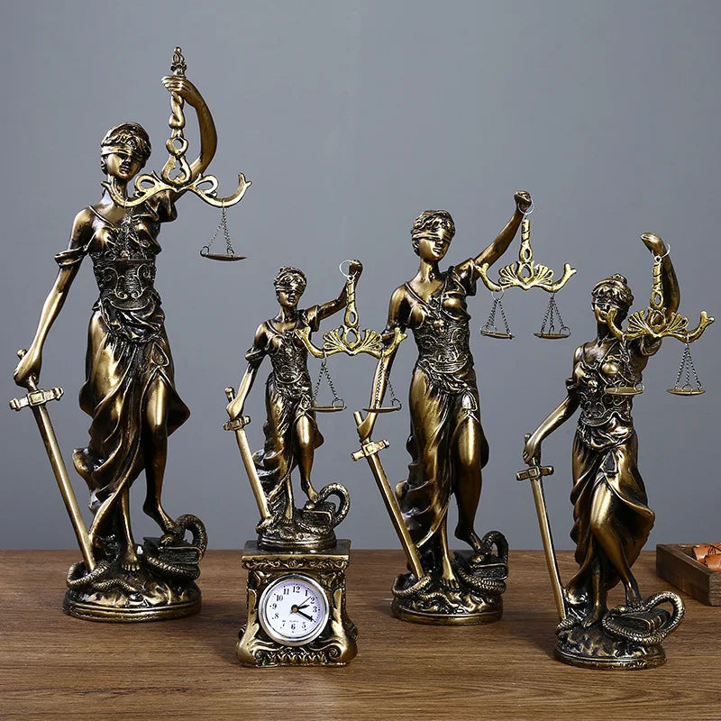 Set of bronze statues of Lady Justice on a wooden surface with a gray background