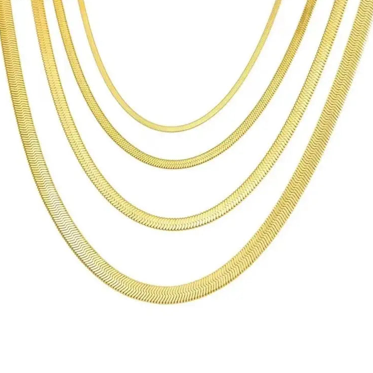 Stacked gold chain flat style necklaces on a white background.