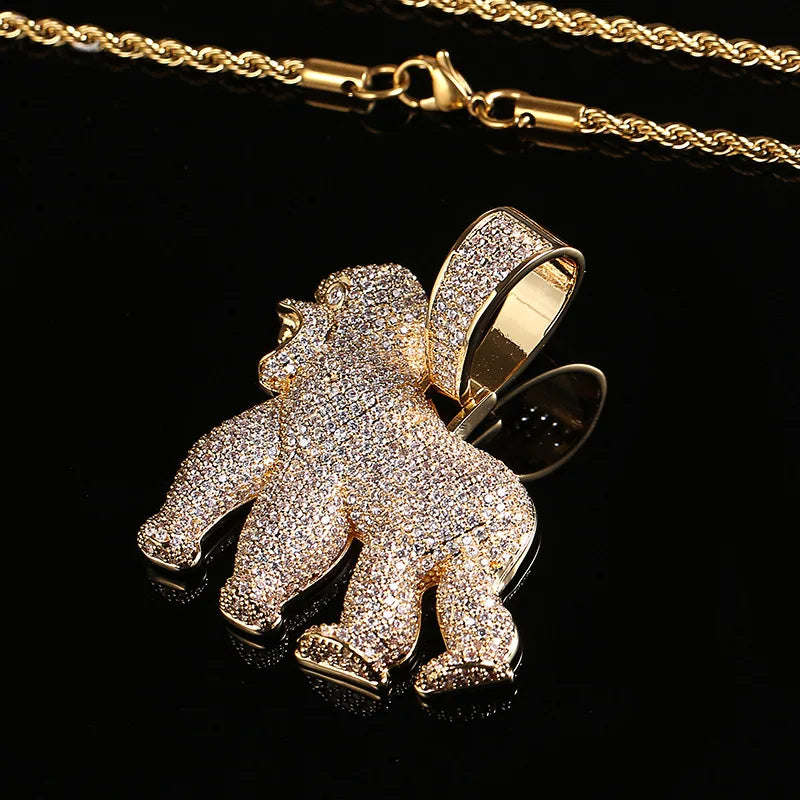 Gold gorilla pendant with diamond CZ accents on a gold chain against a black background