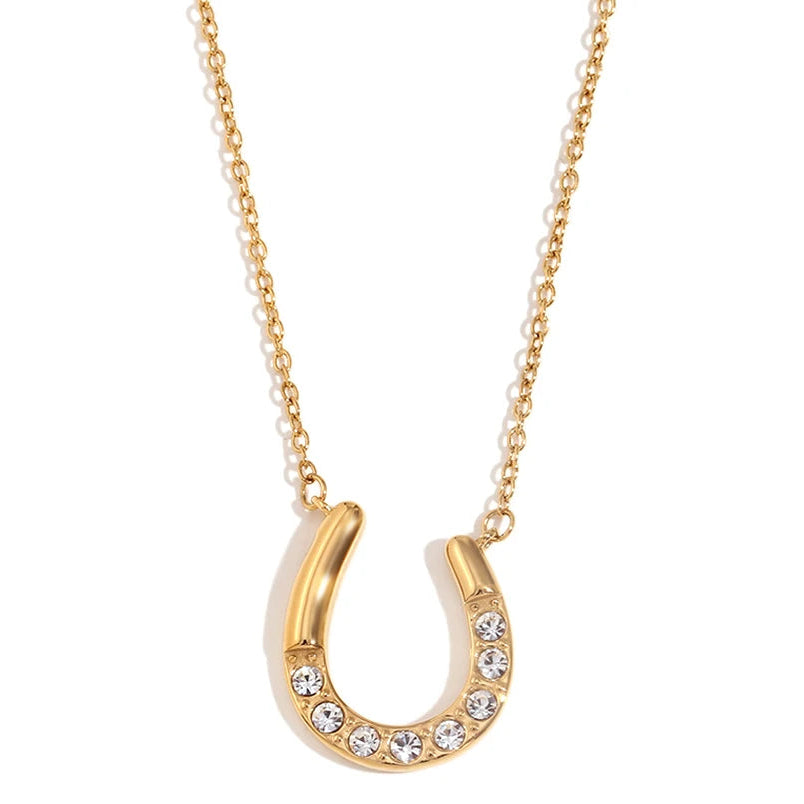 Gold horseshoe necklace with embedded stones on a white background