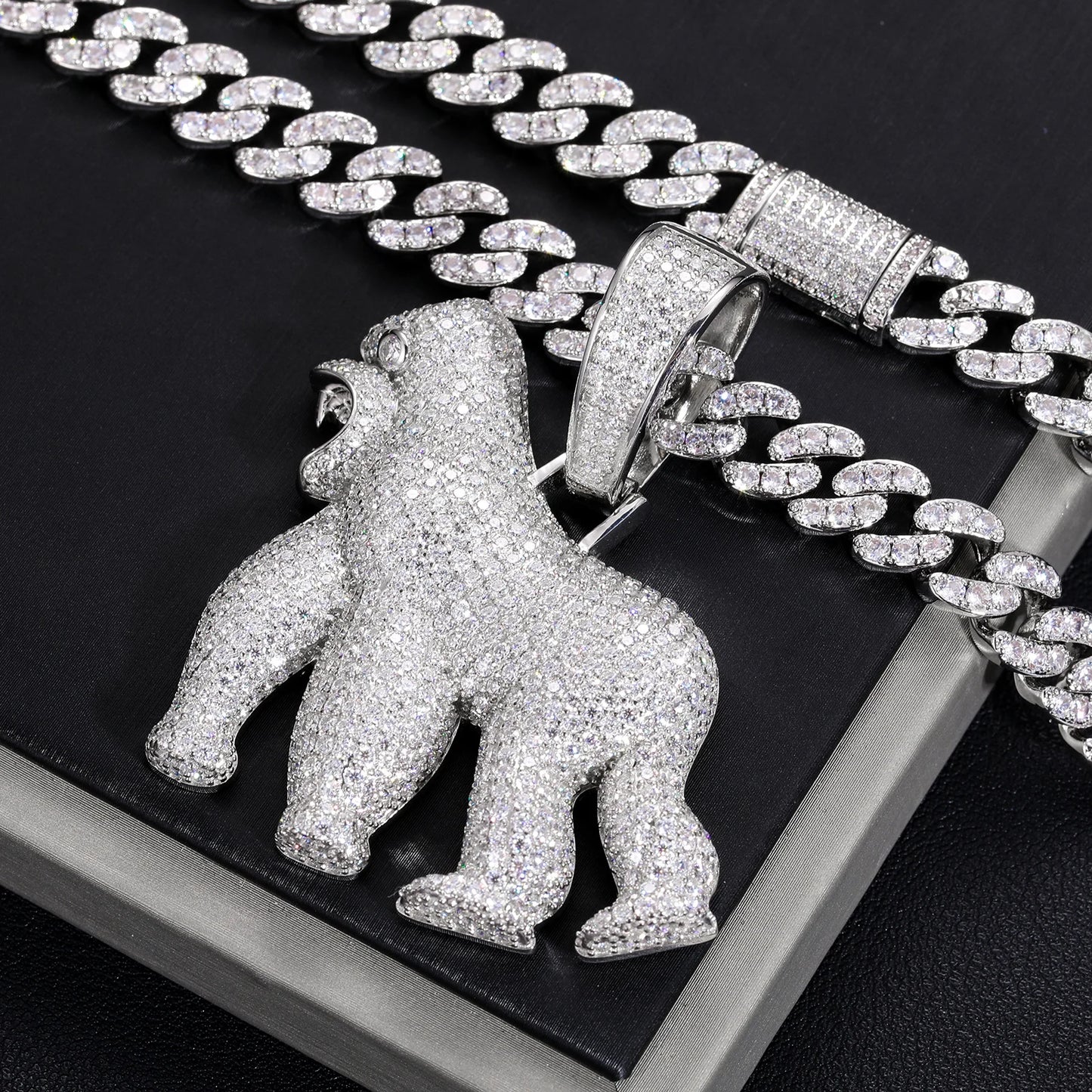 Silver gorilla pendant on a chain against a black background