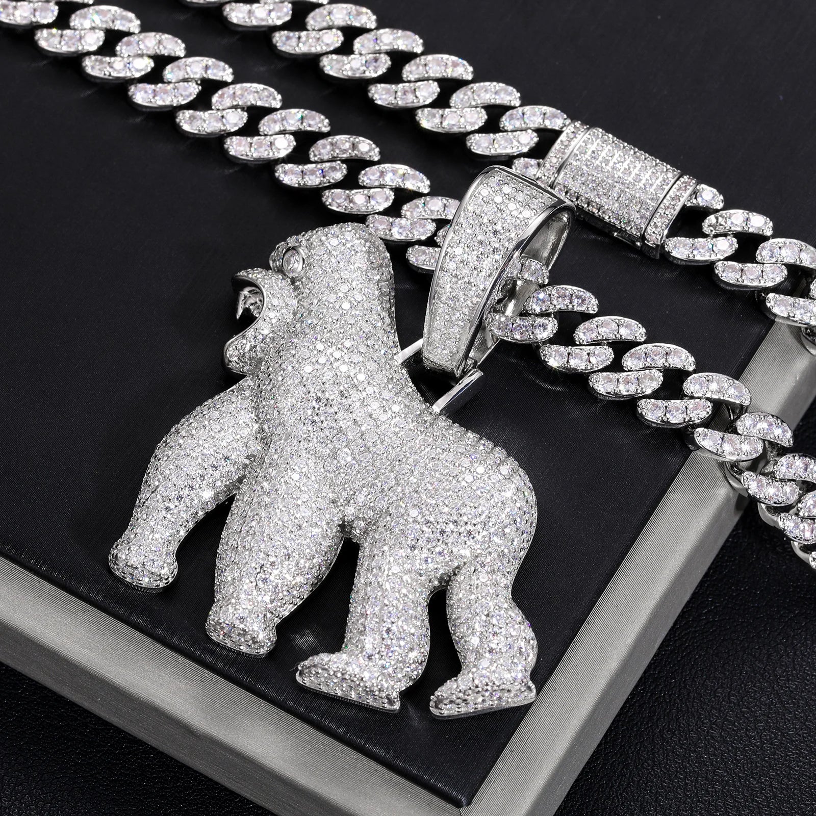 Silver gorilla pendant on a chain against a black background
