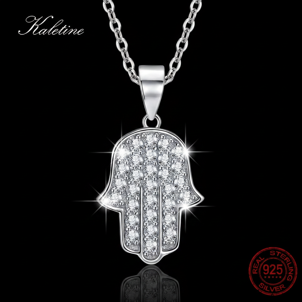 Silver Hamsa hand pendant necklace with clear stones on a black background.