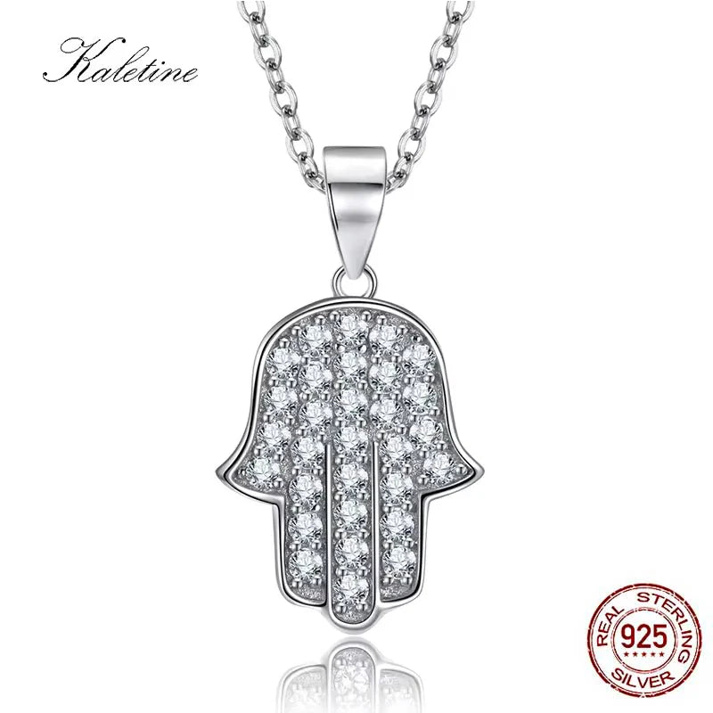 Silver Hamsa hand pendant necklace with clear stones on a white background.