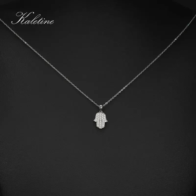 Silver Hamsa hand pendant necklace on a dark background with 'Kalelaine' branding.