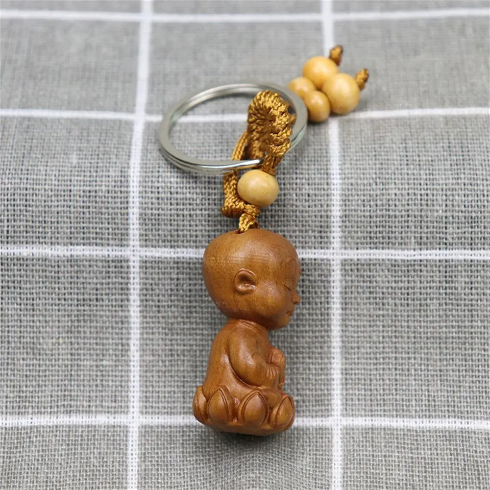 Hand-carved wooden Buddha keychains with prayer and meditation poses