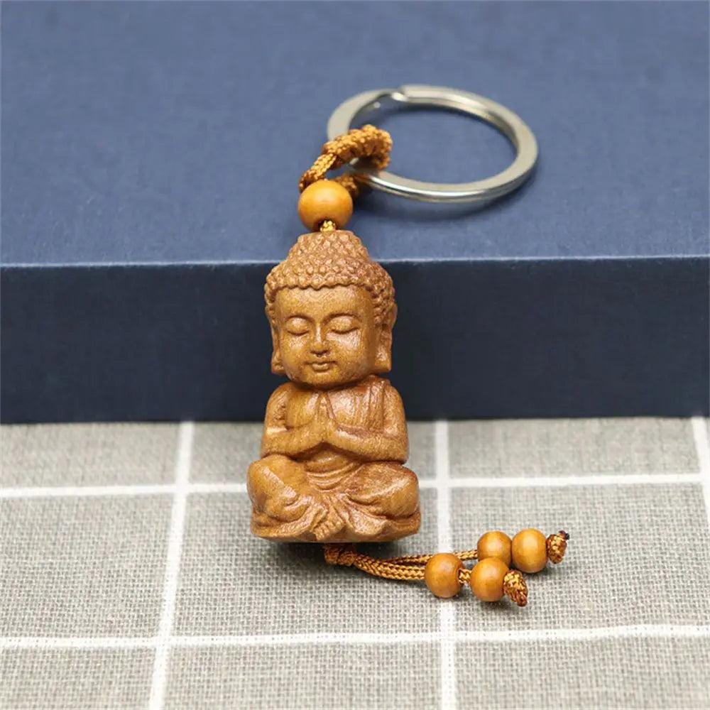 Hand-carved wooden Buddha keychains with prayer and meditation poses