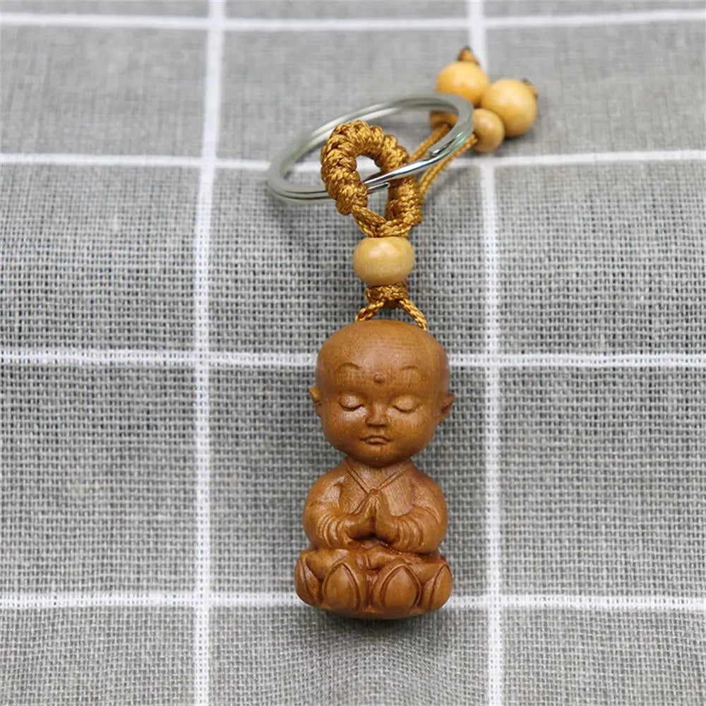 Hand-carved wooden Buddha keychains with prayer and meditation poses