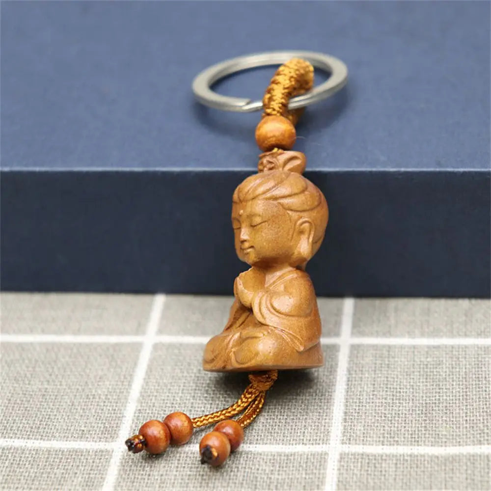 Hand-carved wooden Buddha keychains with prayer and meditation poses