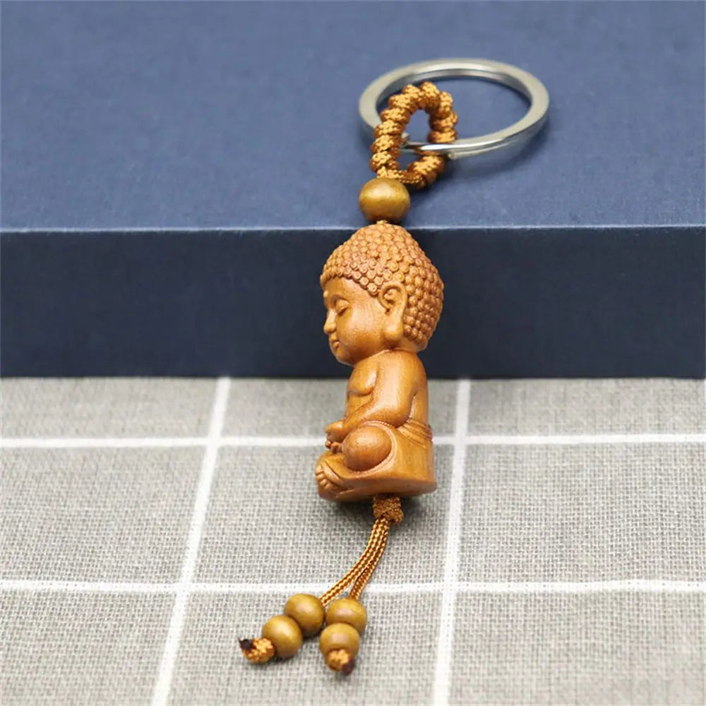 Hand-carved wooden Buddha keychains with prayer and meditation poses