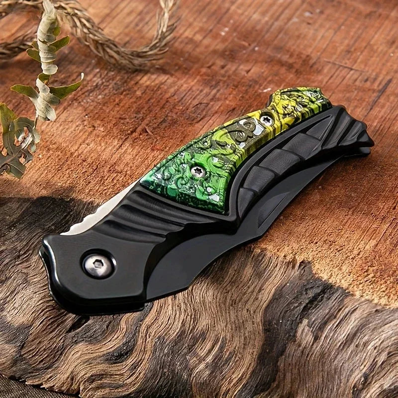 Folding knife with a green and black handle on a wooden surface