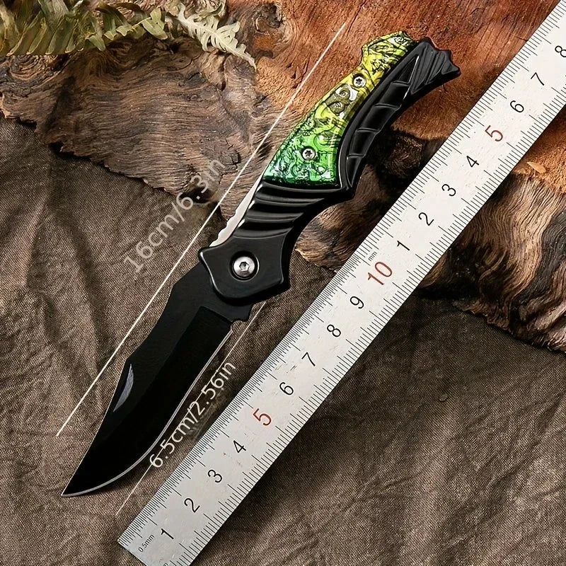 Folding knife with decorative handle on a wooden surface next to a ruler for scale.