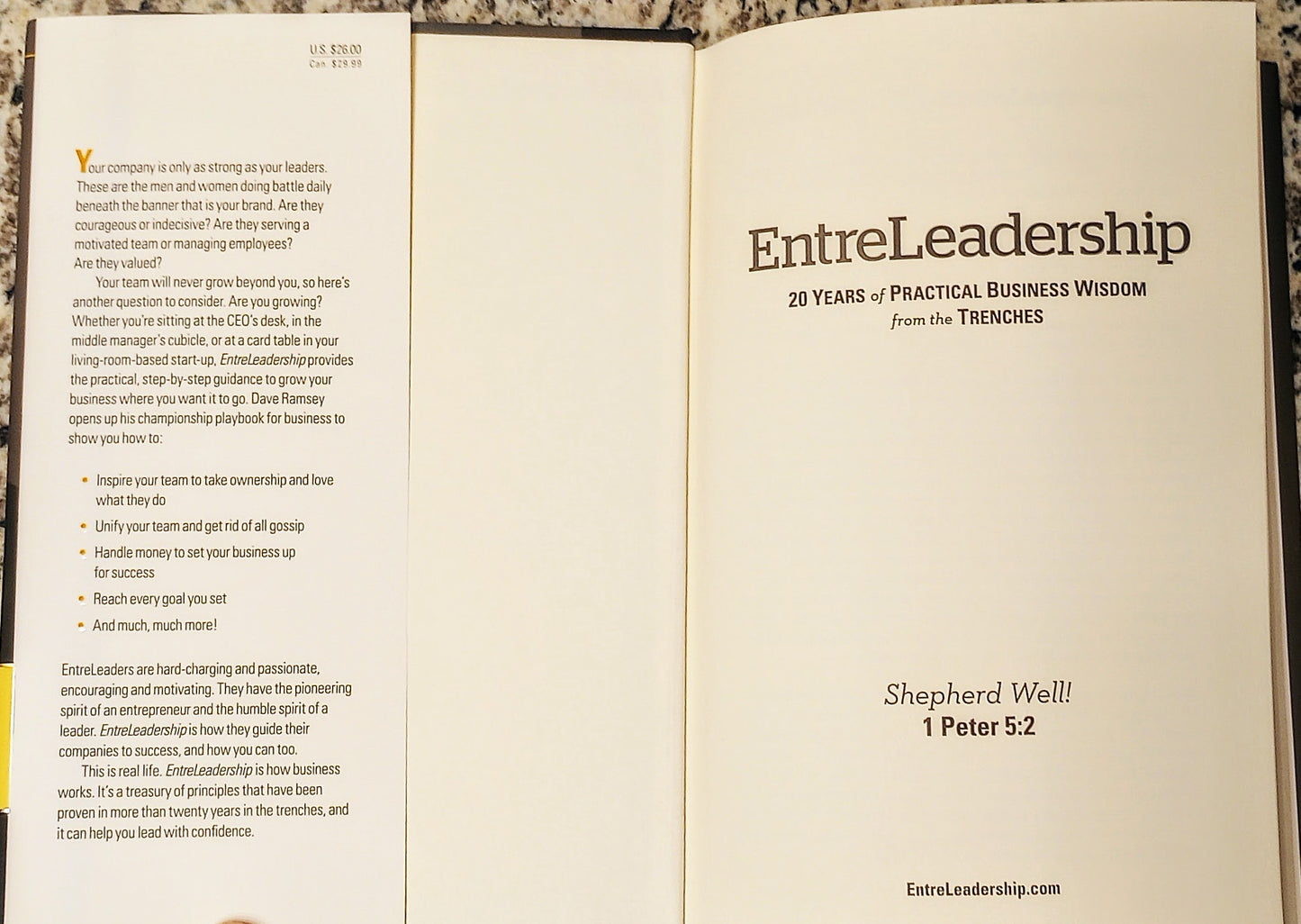 Open book with 'EntreLeadership' title and text on a wooden surface