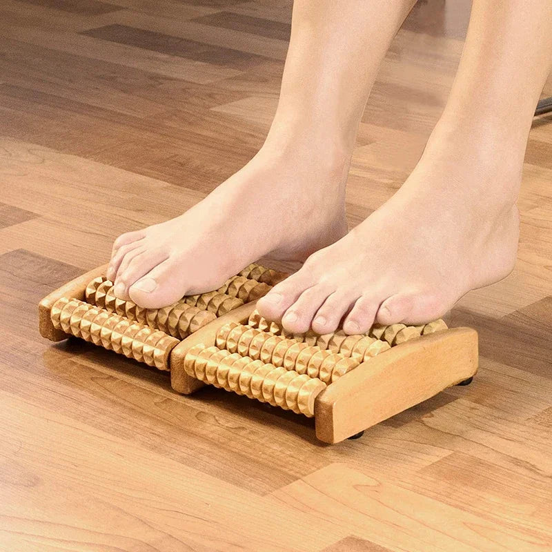 Person using a wooden foot roller on a wooden floor