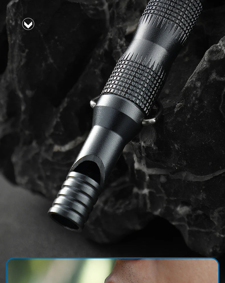 Close-up of a black power whistle blow hole on a textured surface