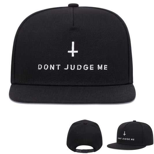 Black cap with 'DON'T JUDGE ME' text and cross symbol on a white background