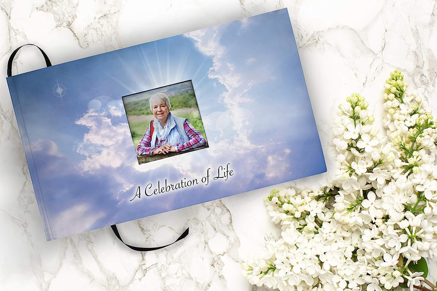 Front book cover view of 'Holy Heavens Dearly Departed Photo Funeral Guestbook Attendance Log' featuring a woman on the cover of the "Celebration of Life" funeral guest attendance guestbook.