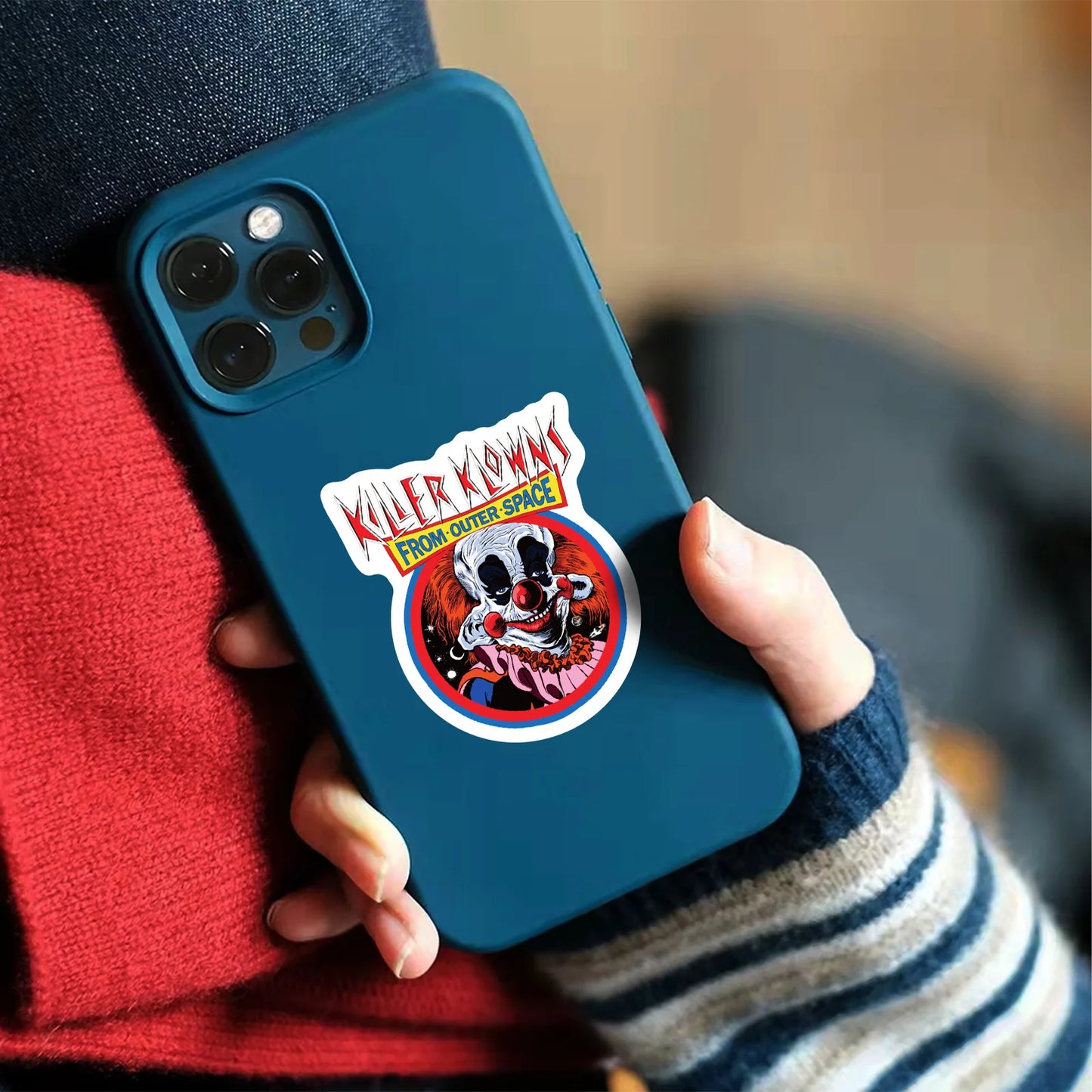 One of the decals from the Horror Sticker set bundle image of person holding a phone with a 'Killer Klowns from Outer Space' on a phone case.