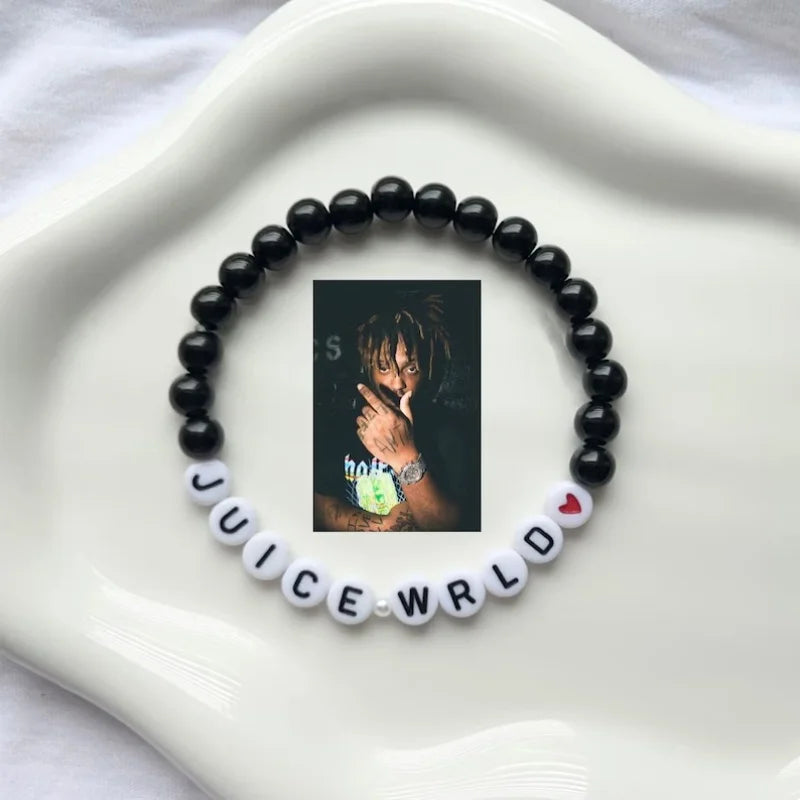 Black beaded bracelet with 'Juice WRLD' letter beads on a white surface
