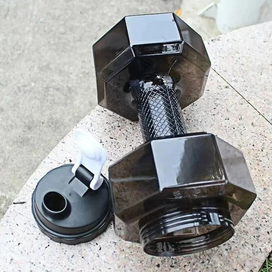 Black dumbbell-shaped water bottle on a concrete surface
