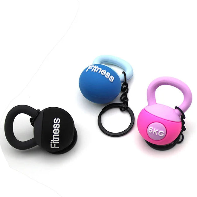 Three small fitness kettlebell keychains on a white background