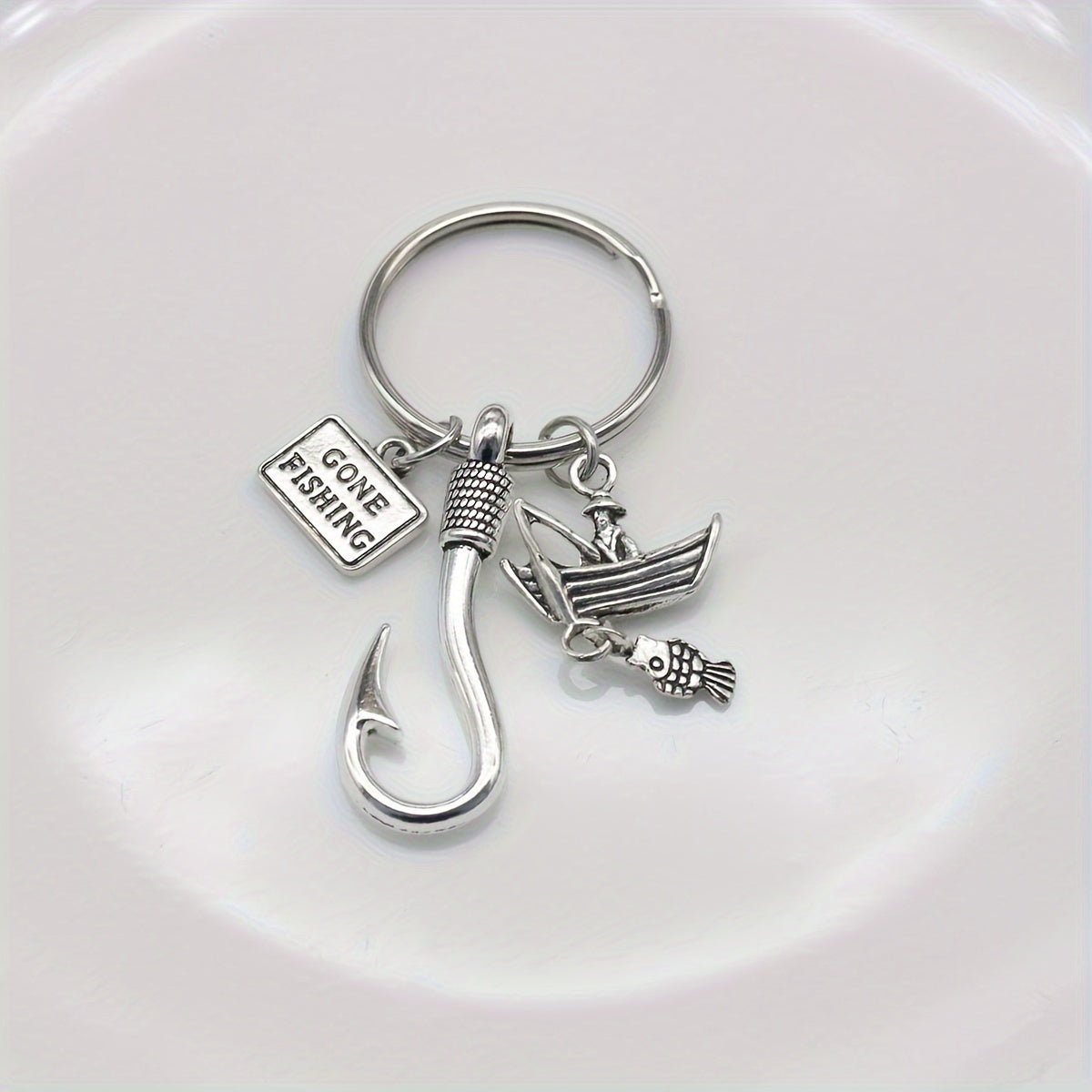 Silver fishing-themed keychain with charms on a white background