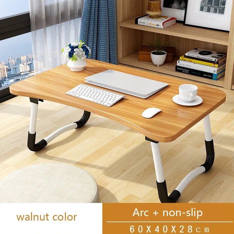 Wooden laptop desk with keyboard and mouse on a wooden floor, with a cityscape view.